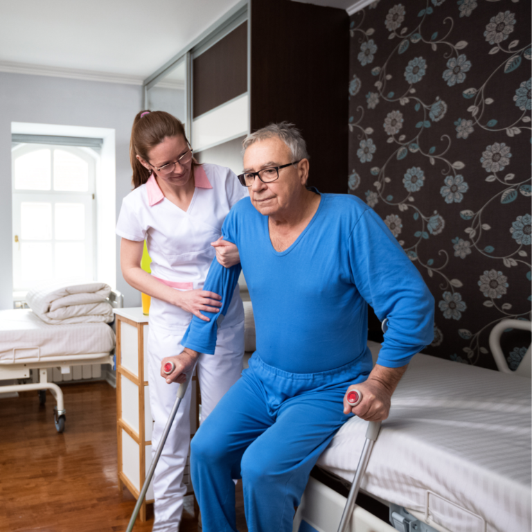Man getting of of bed using crutches and being helped by a nurse.