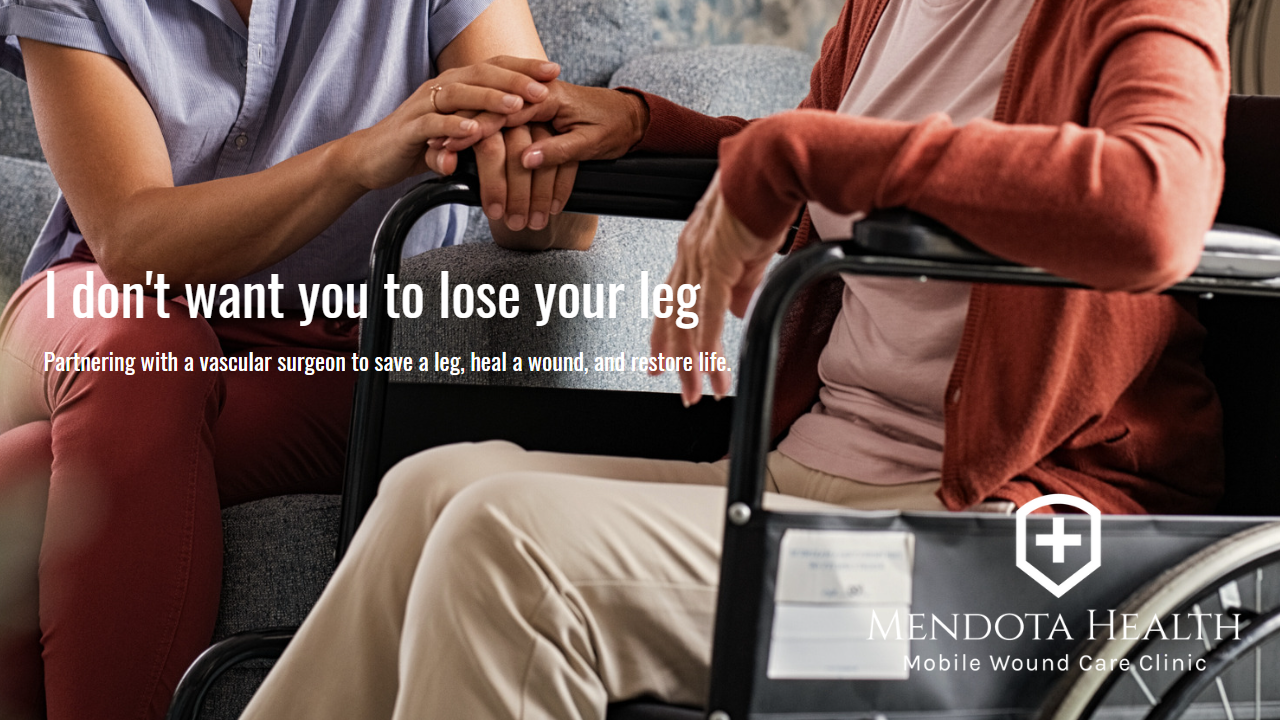 Person in a wheel chair holding the hand of a medical professional.